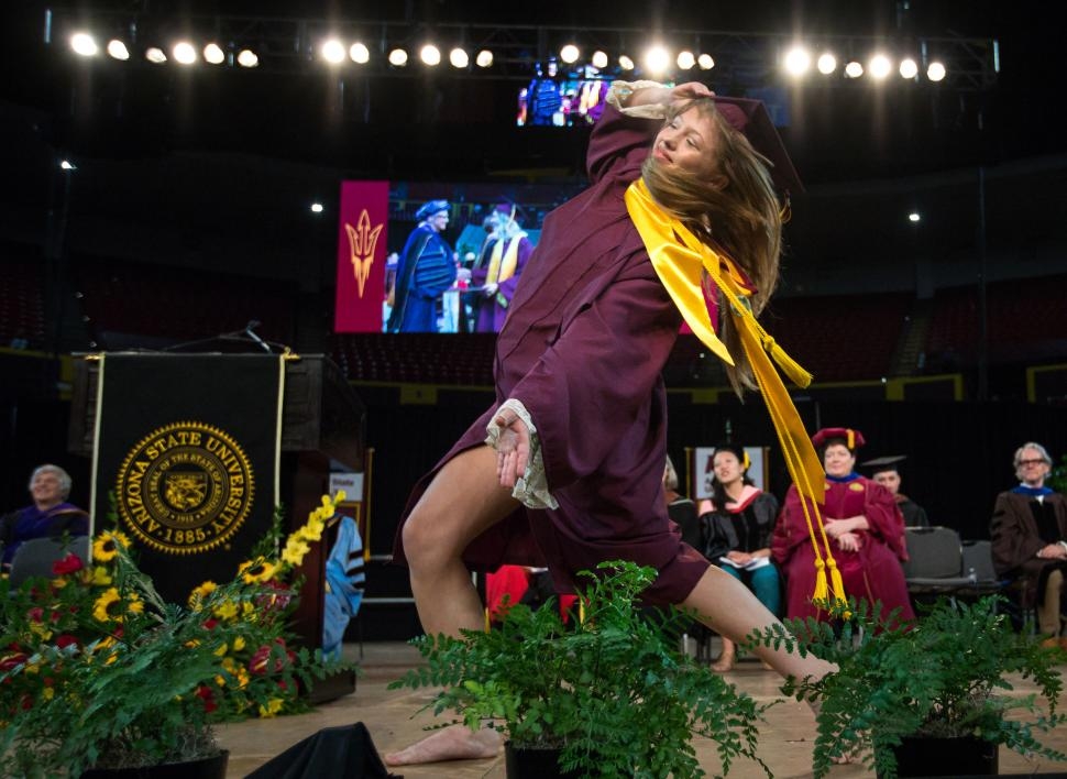 graduate dancing across stage