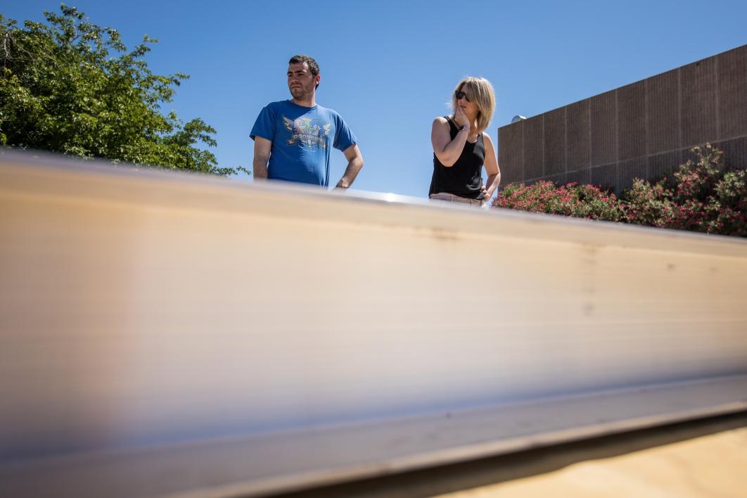 Two people observe the metal hyperloop track