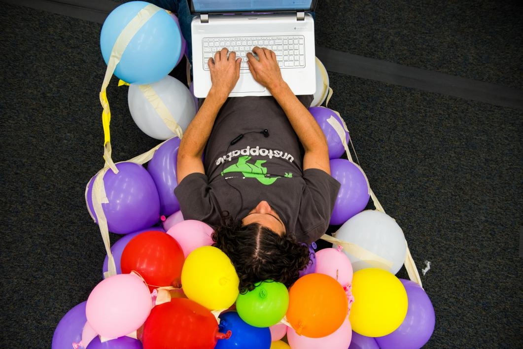 Man sits on a chair of balloons