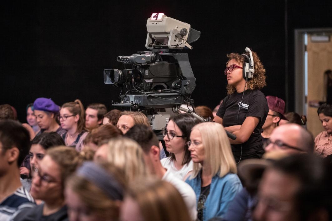 A student runs the camera at a news show taping