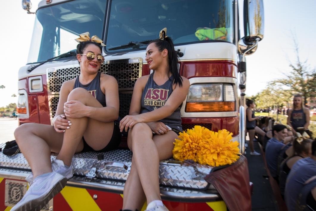 two students talking on front of fire truck