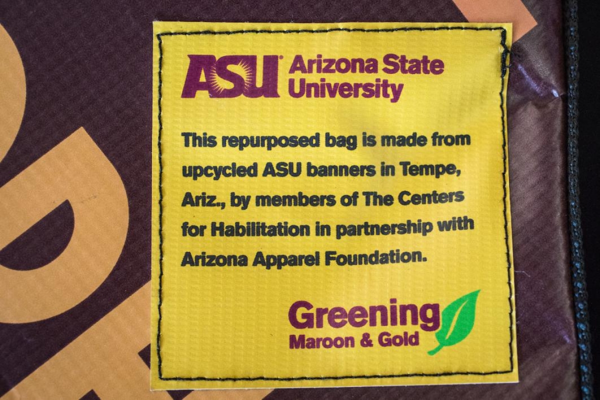 statement on banner bags: This repurposed bag is made from upcycled ASU banners in Tempe, Ariz., by members of The Centers for Habilitation in partnership with Arizona Apparel Foundation