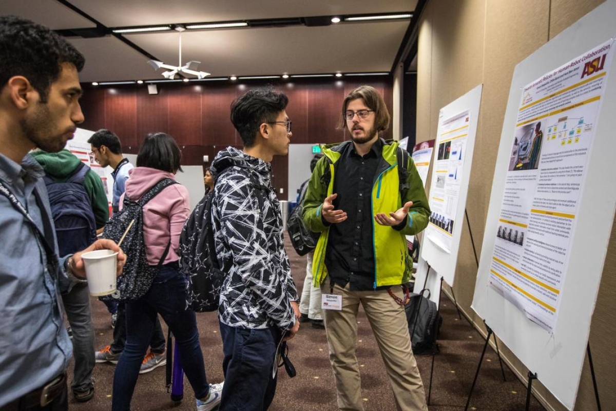 A doctoral student shares his research at a robotics event