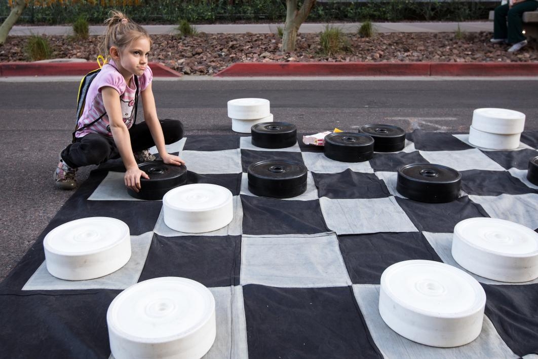 girl playing with giant checkerboard