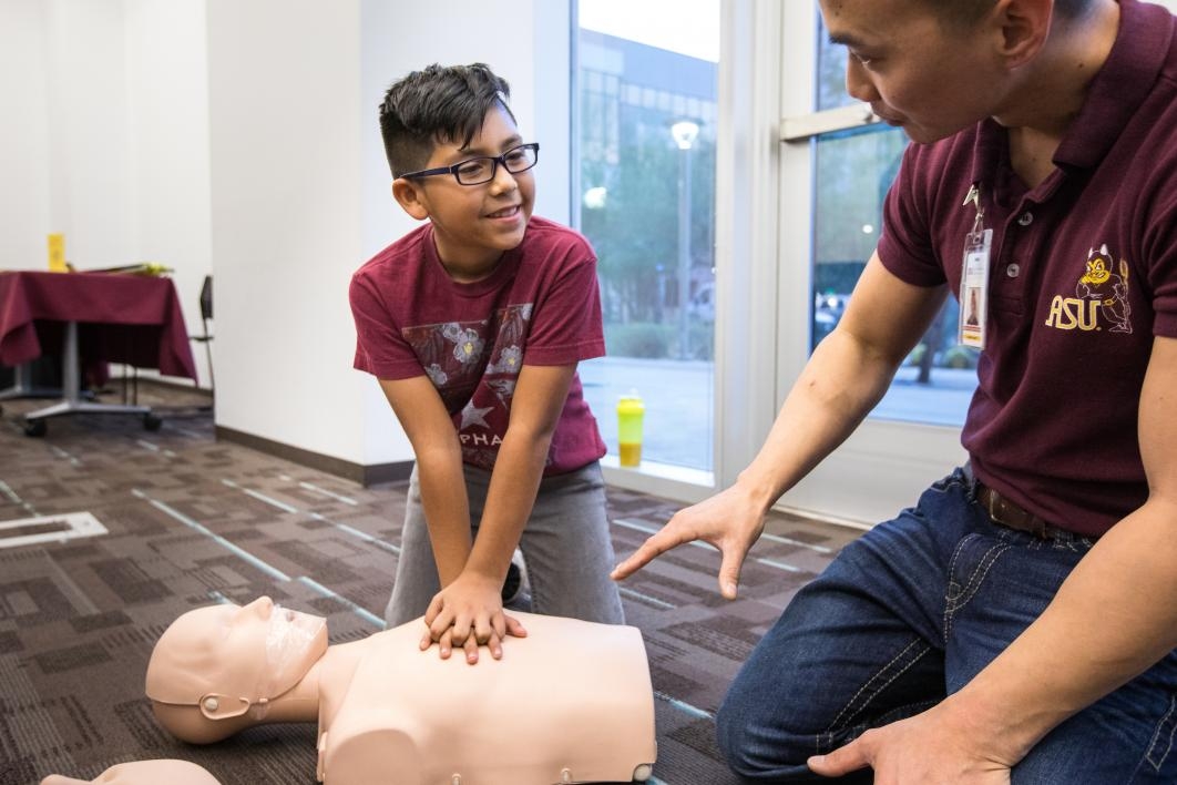 young boy learning CPR