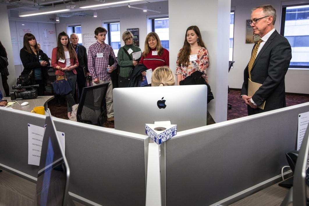 people standing in front of a computer listening to person talk
