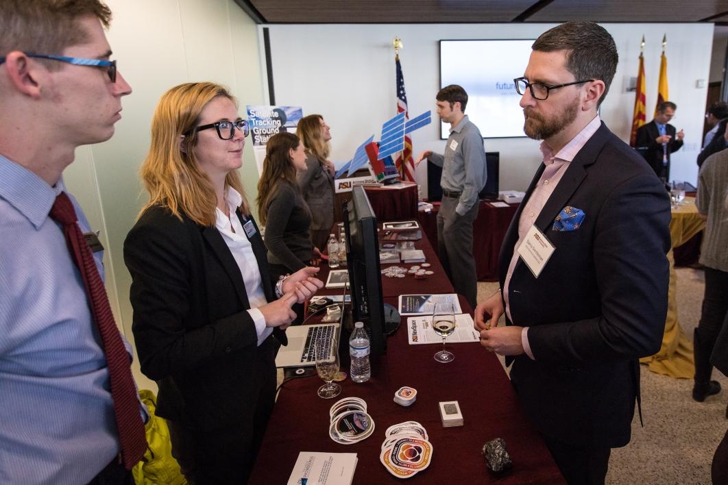 Psyche researchers speak to visitors at a reception