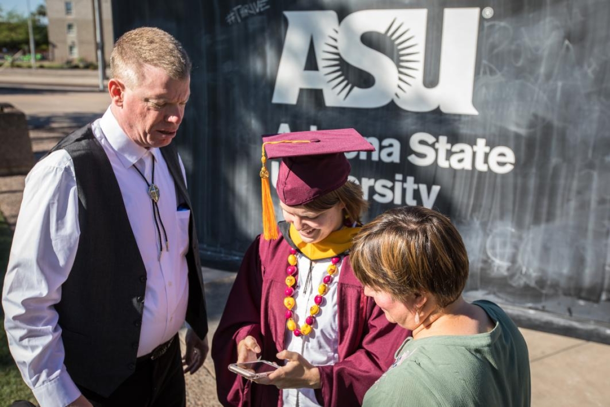 graduate looking at photos on a phone