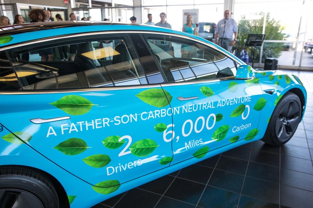 car with wrap on it that says: A father-son carbon neutral adventure