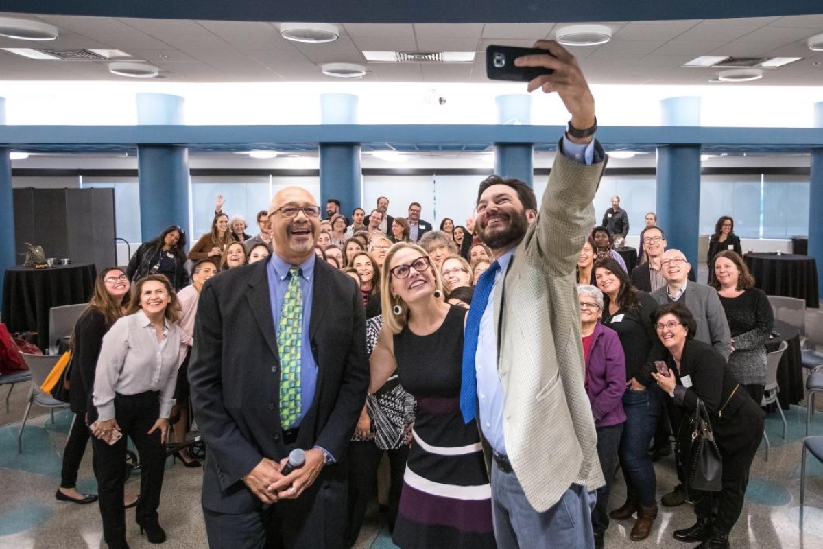 three people taking a selfie in front of a crowd