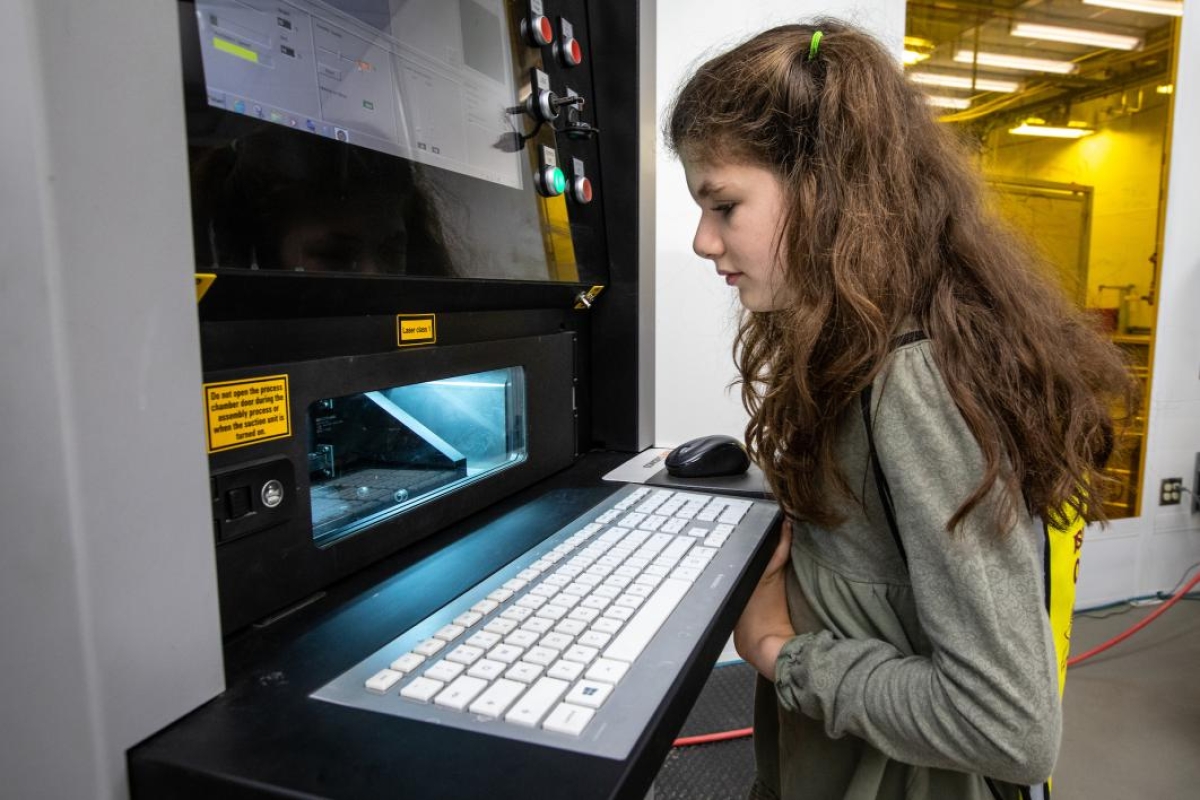 girl watching a 3d printer work