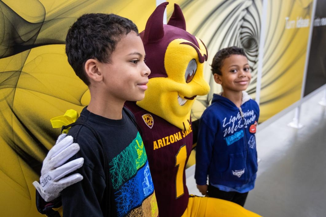 two young boys pose with asu mascot sparky