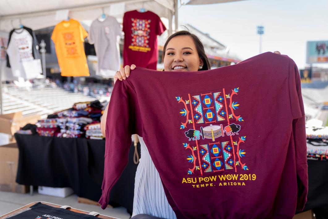 A vendor holds up a T-shirt at the ASU Pow Wow