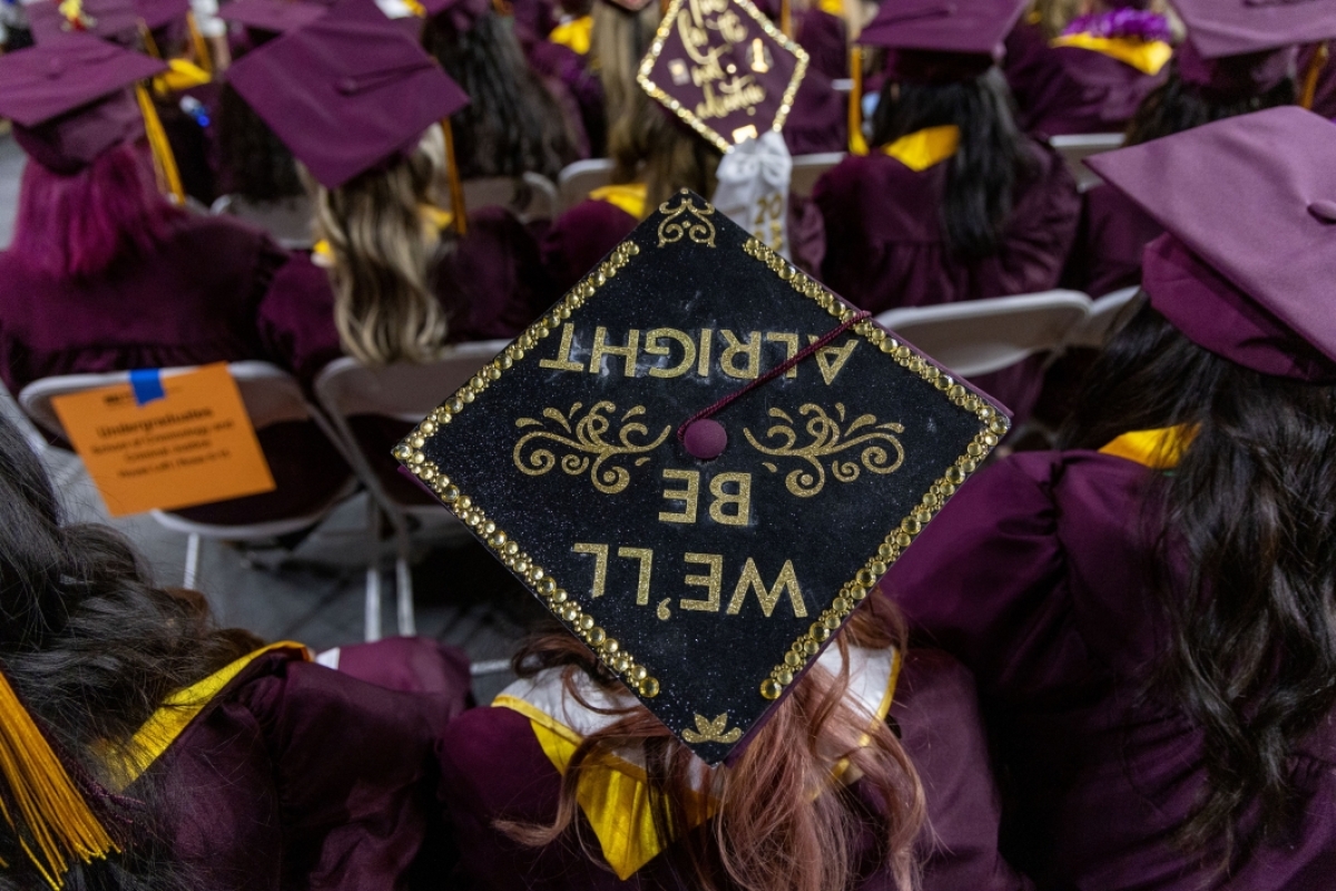 A close-up of a mortarboard with an upside down message.
