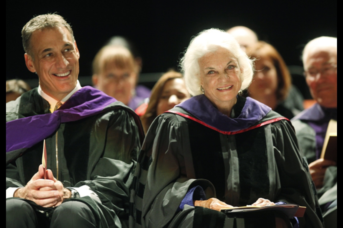 Sandra Day O'Connor smiles onstage at graduation wearing regalia
