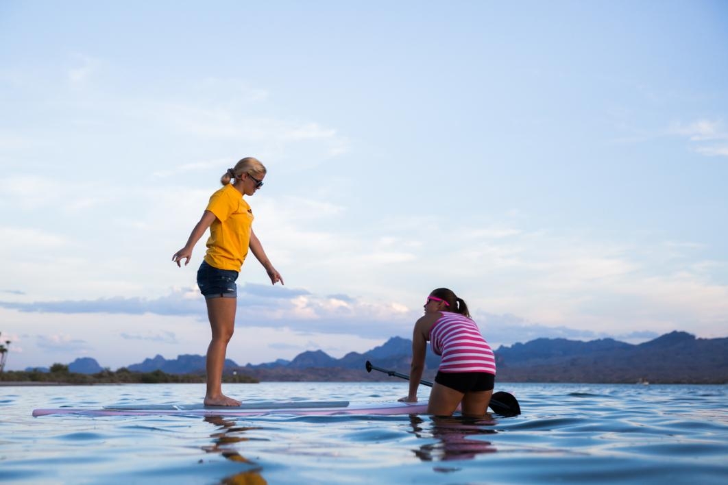 Women getting on a paddleboard.