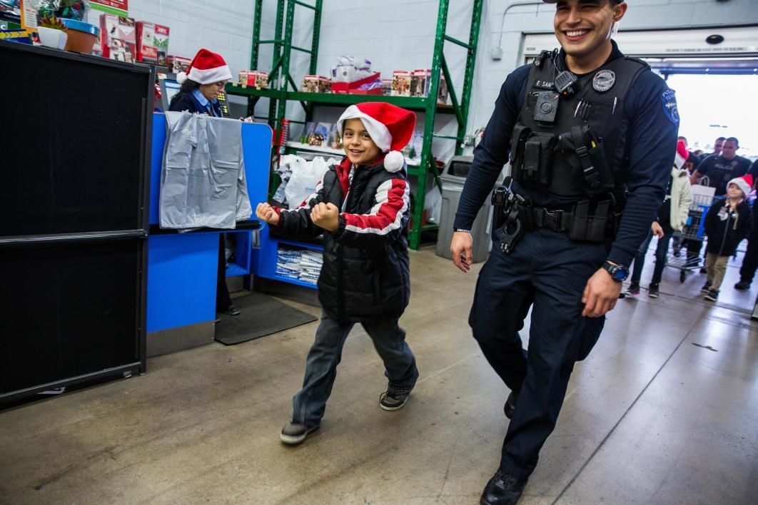 child and police officer walking into store