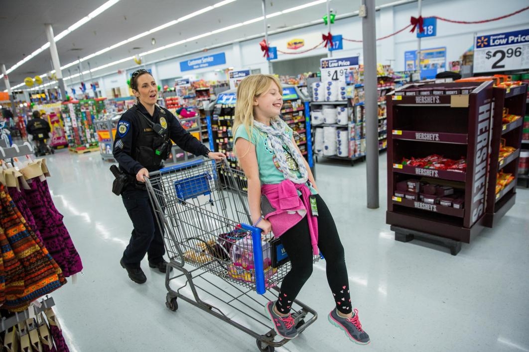 officer pushing child in a shopping cart