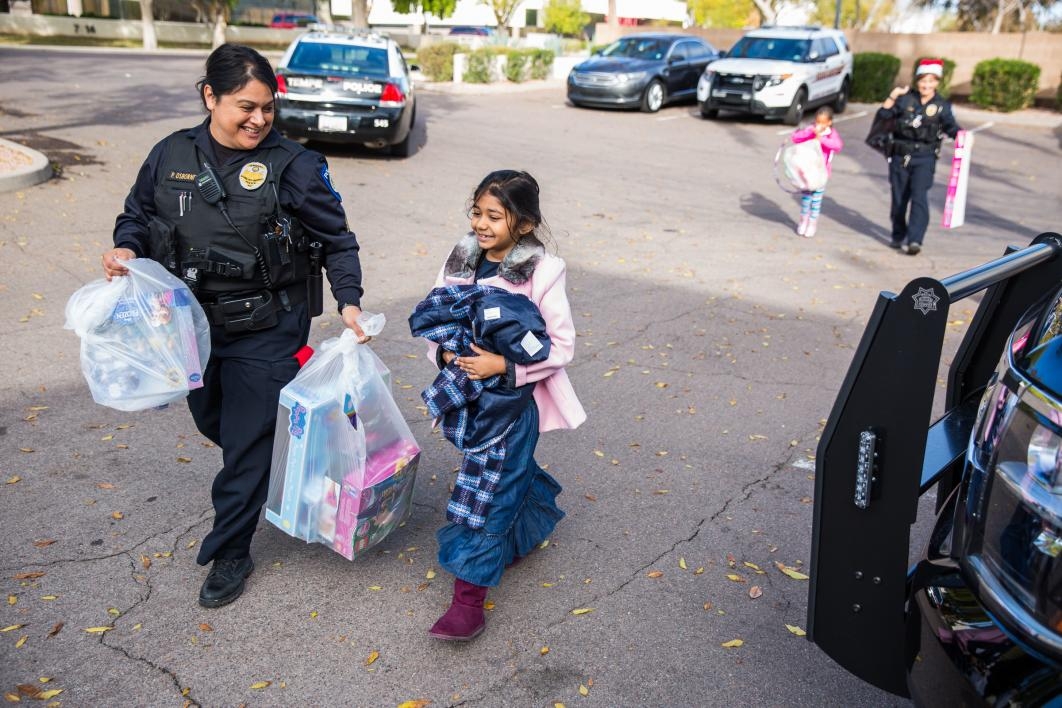 officer and child carrying shopping bags