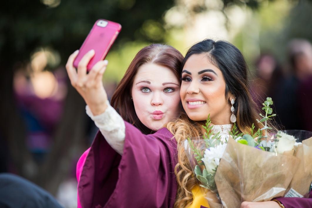 Friends take a selfie during a graduation.