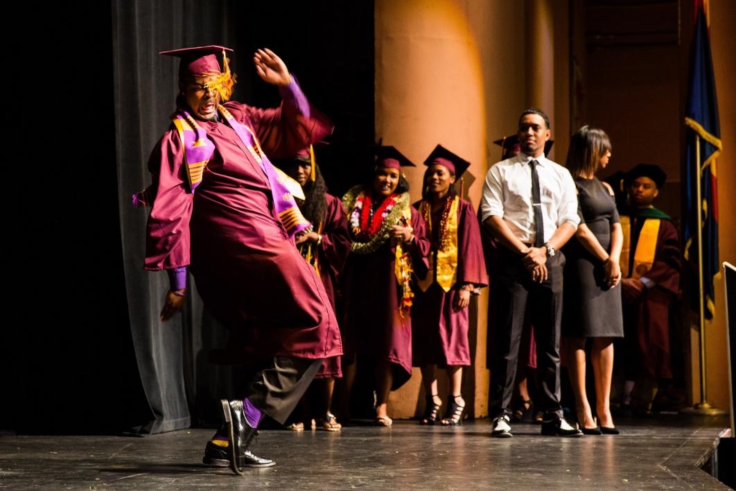 graduate dancing across stage