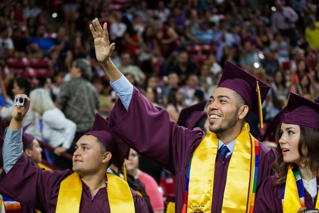 graduate waving to family members 