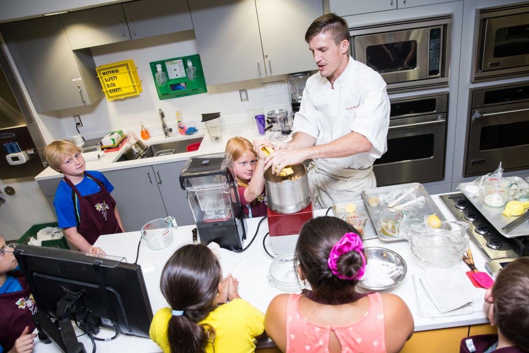 A chef teaches young students how to cook at Camp Crave