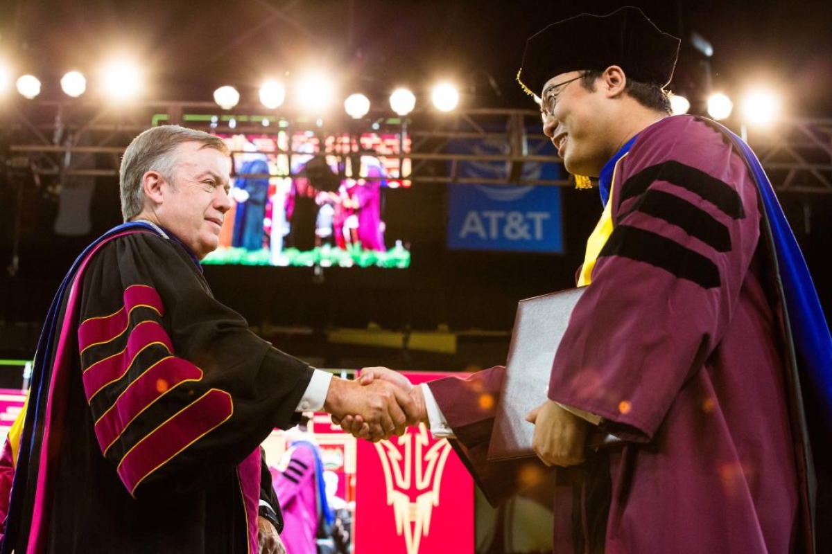 student shaking hands with ASU President