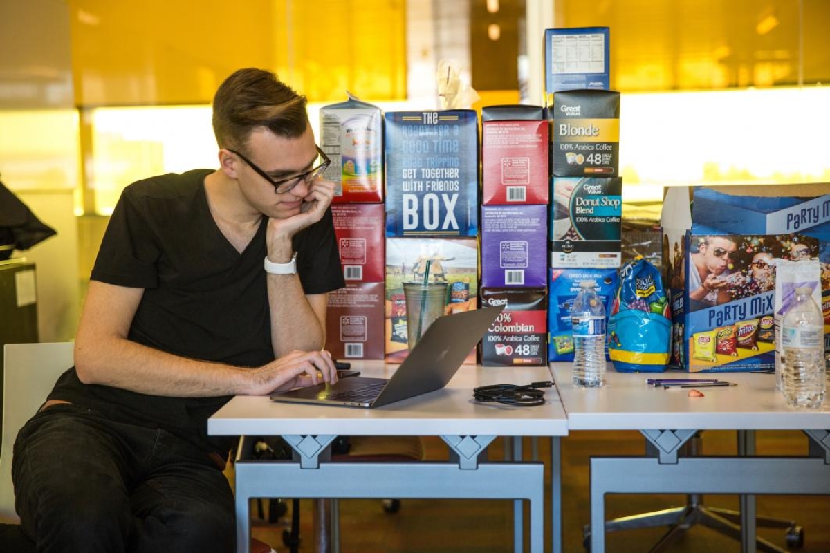A man guards the snacks at the hackathon
