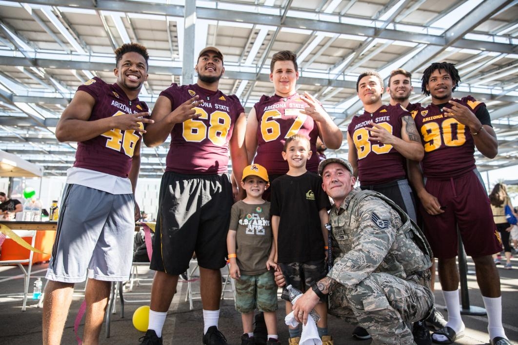 A soldier and his kids pose with ASU football players after the 2017 Pats Run