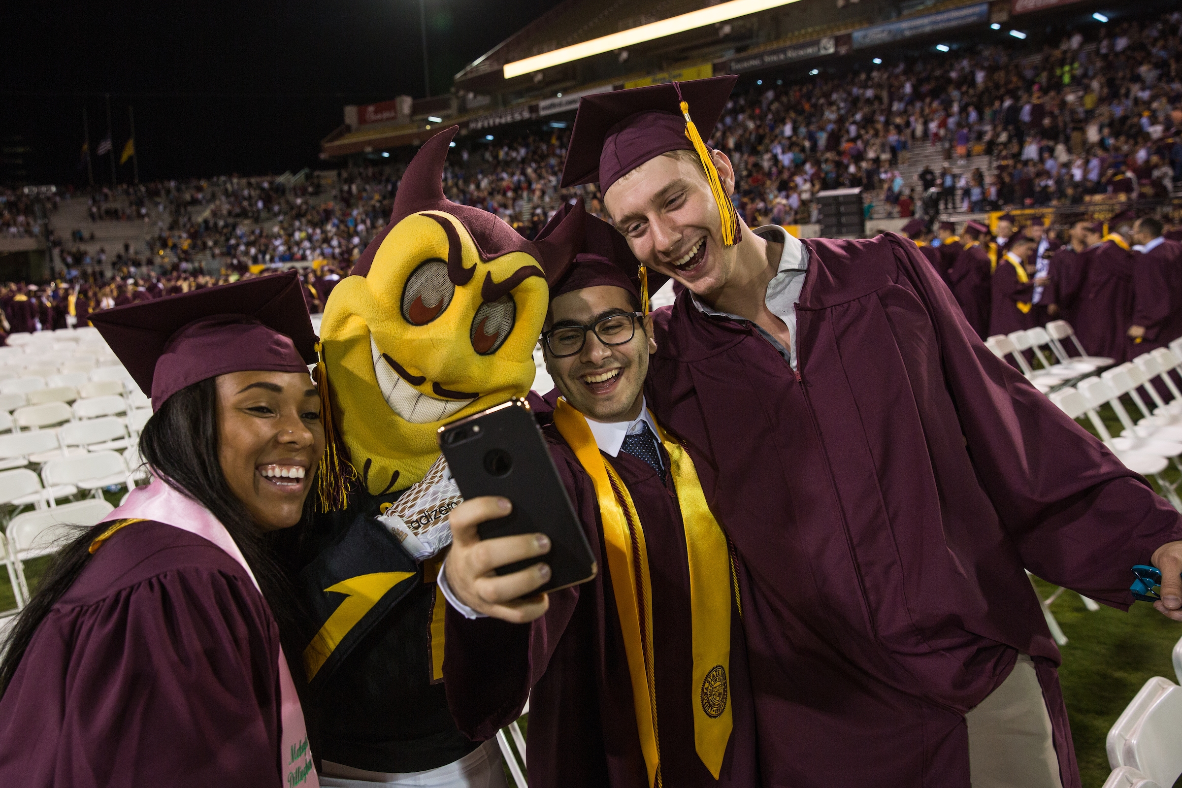 New ASU graduates pose with Sparky at commencement