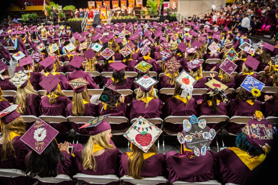 crowd of graduates with decorated caps