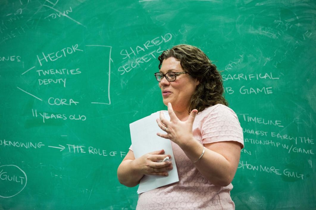 A woman stands at a chalkboard