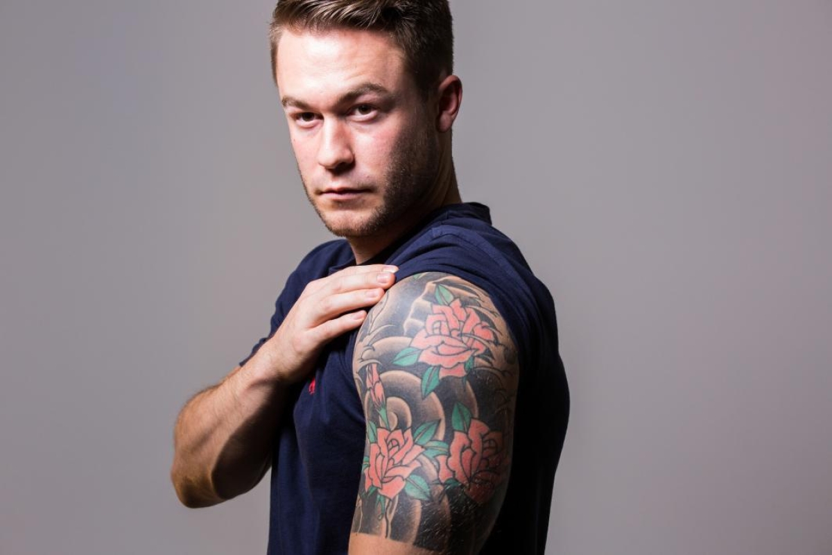 portrait of man with Japanese tattoo on arm