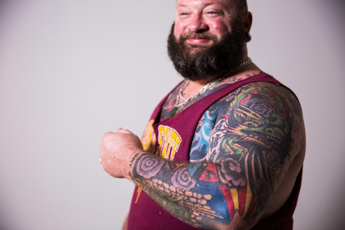 man posing for photo with many tattoos on his arm