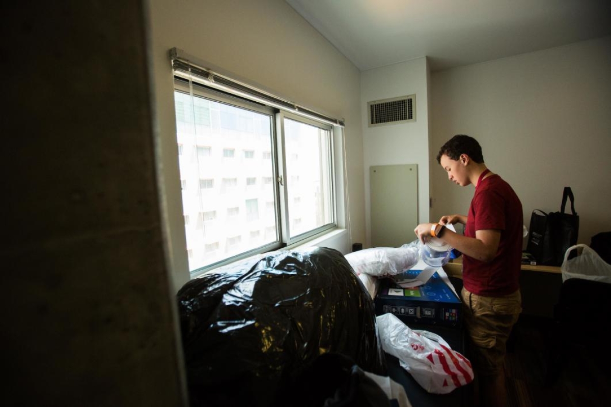 A student unpacks in his dorm room