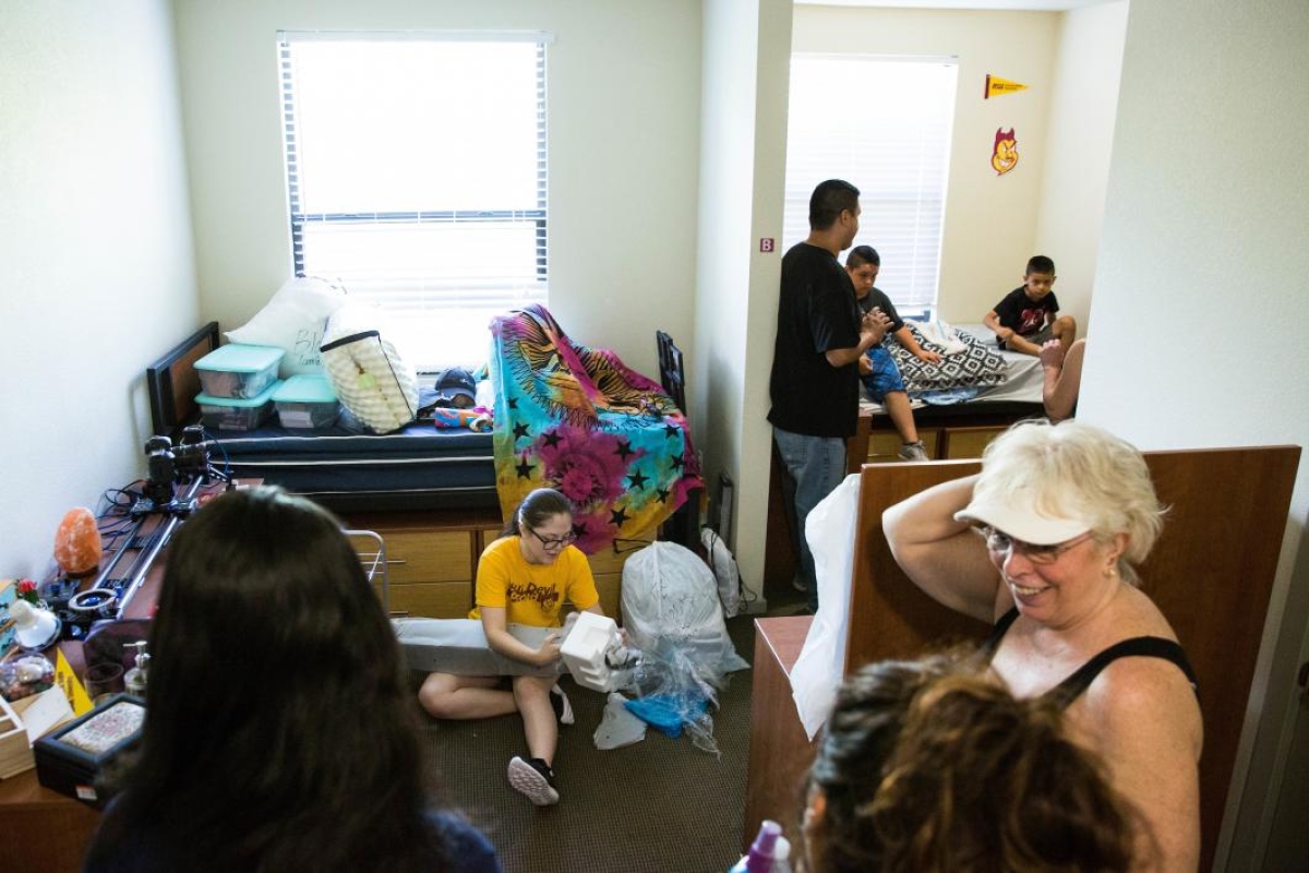 Families unpack in a dorm room
