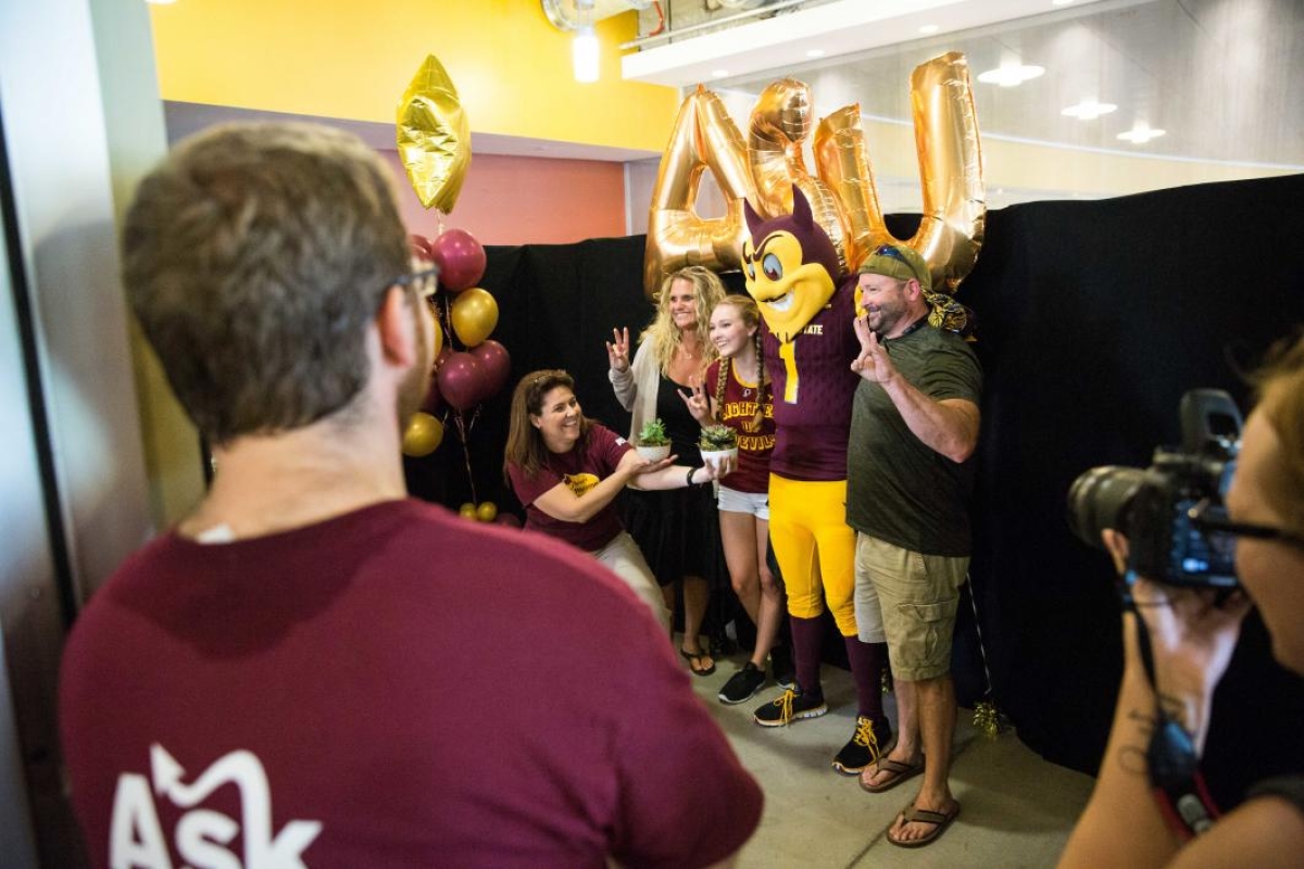 A family poses with Sparky at move-in
