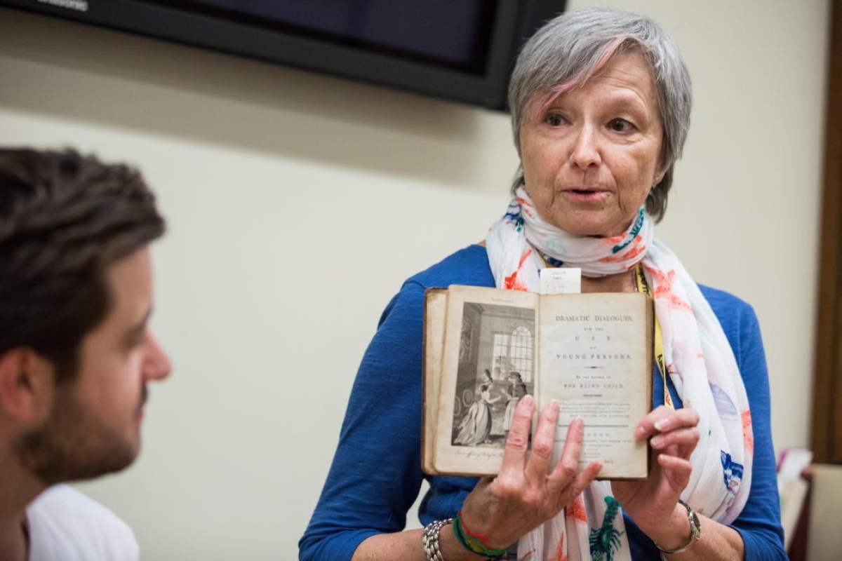 Child Drama collection archivist Katherine Krzys shares a historical book with students