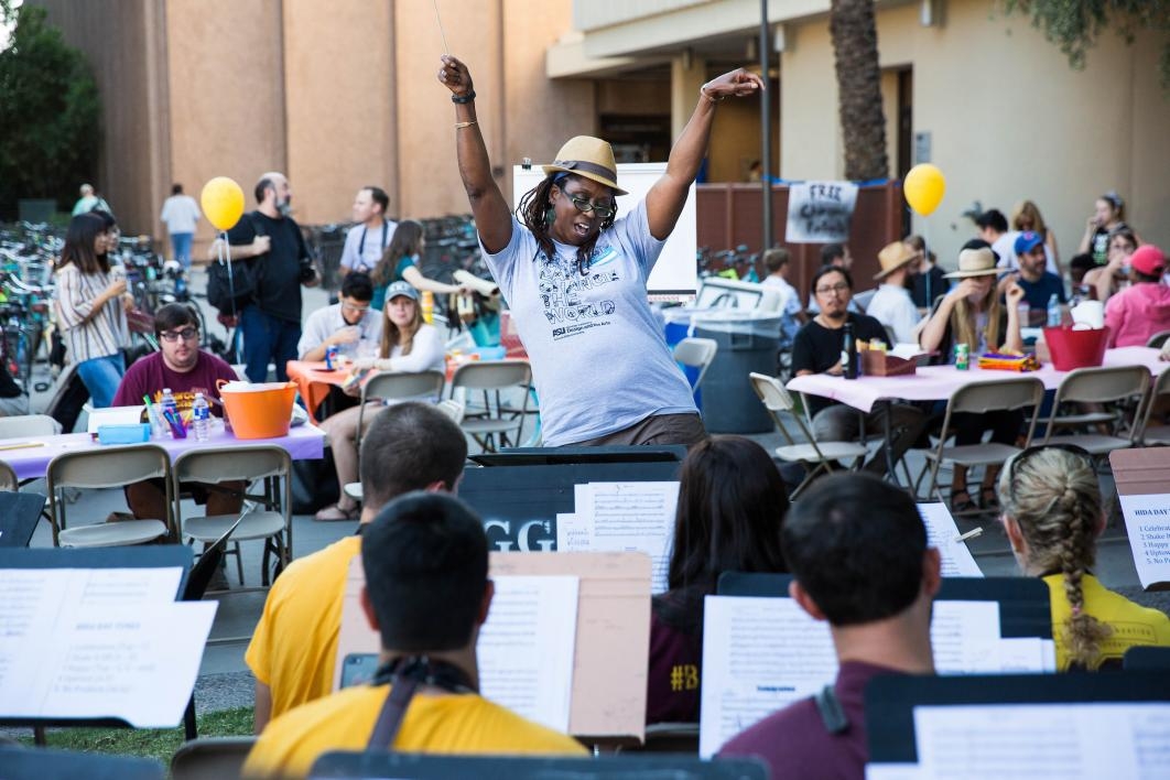 Woman conducts a brass band at Herberger Institute Day