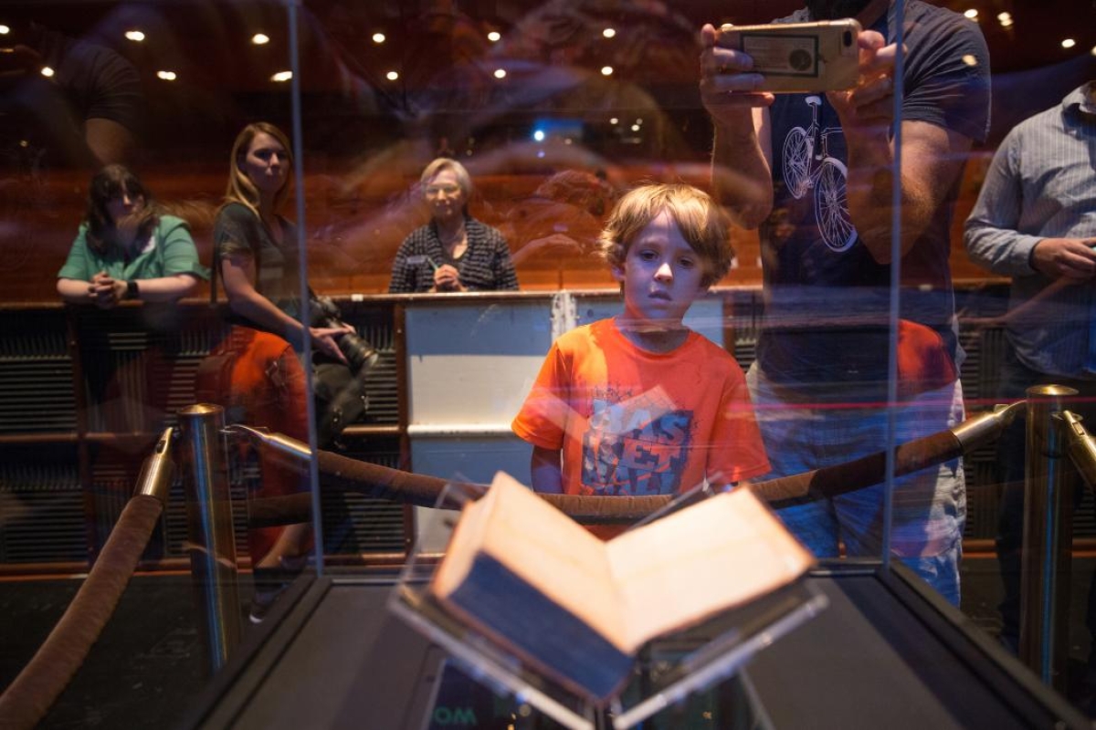A boy looks at the Federalist Papers in a case at ASU Gammage