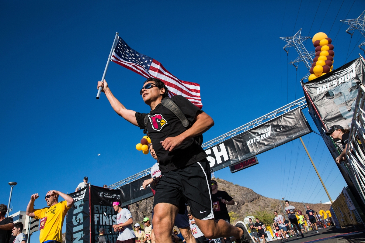 man carrying flag passing finish line in race