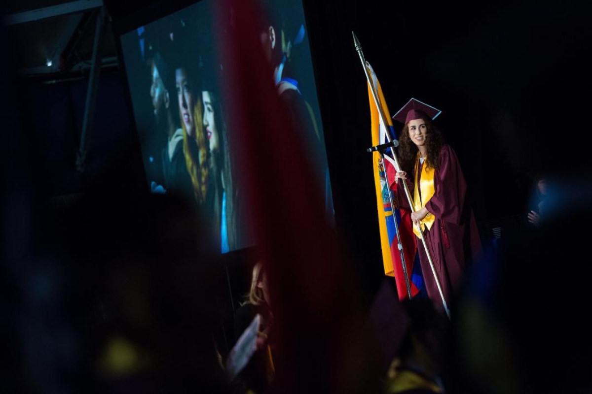 woman holding flag at graduation ceremony