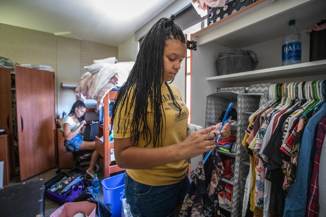 student organizes her dorm closet