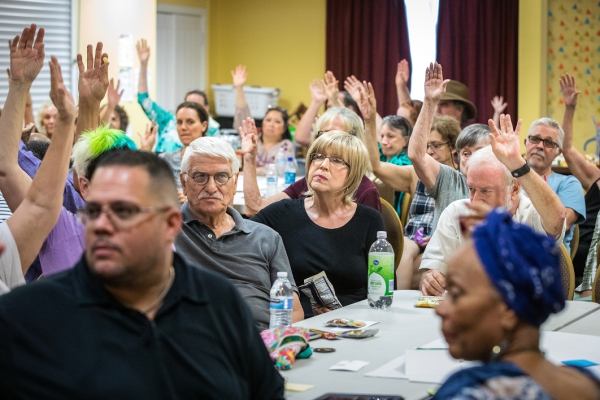 People raising their hands at a seminar