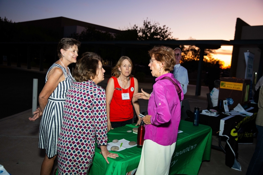 A Franciscan Renewal Center representative speaks to women at an outdoor table