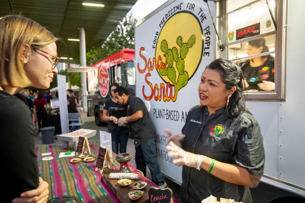 Sana Sana Foods owner Maria Parra Cano talks with a customer about her plant-based ancestral foods at her food truck