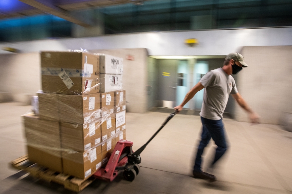 A man moves a pallet of boxes of computer equipment