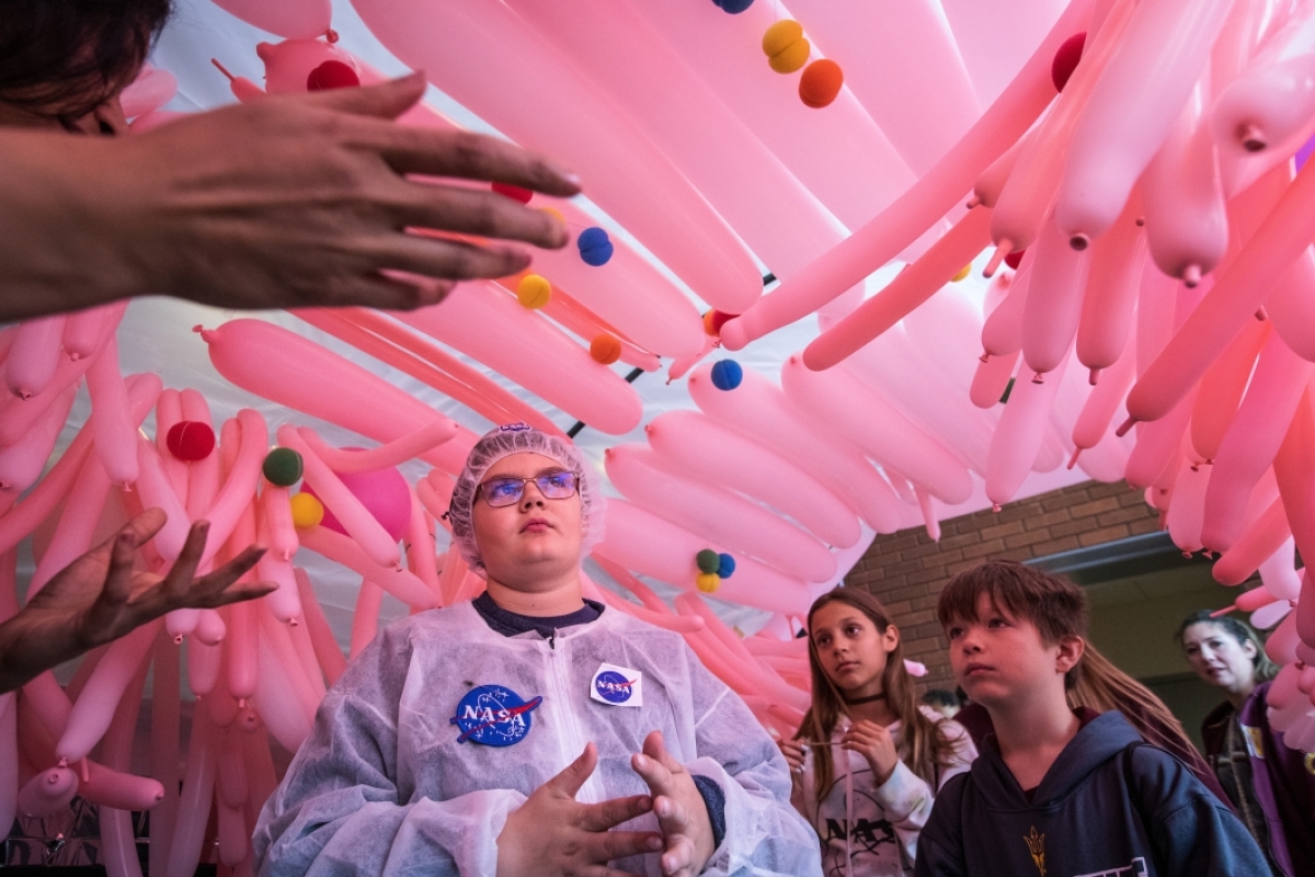 group of kids under balloon display