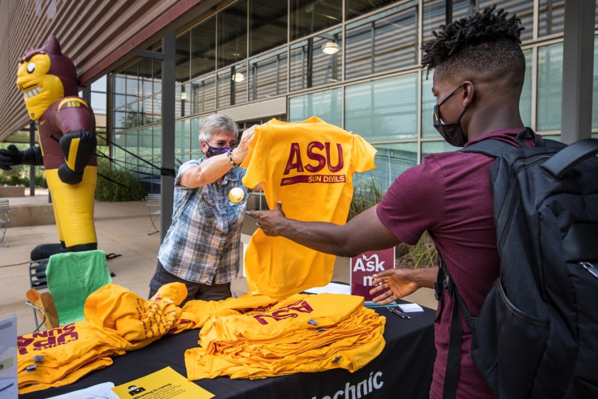 professor handing student an ASU tshirt